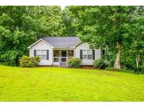 Charming single-story home with lush lawn and mature trees at 305 Saddle Wood Dr, Canton, GA 30114