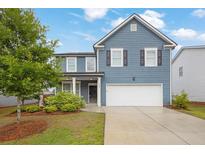 Charming two-story home with blue siding, manicured lawn, and attached two-car garage at 3699 Broadwick Ln, Lithonia, GA 30038