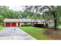 Charming ranch-style home with red garage doors and lush greenery at 4845 Willow St, Acworth, GA 30101