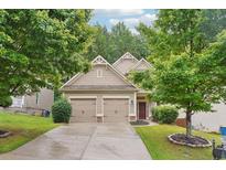 Traditional home featuring a well-manicured lawn, mature trees, and a two-car garage at 2366 Proctor Creek Enclave, Acworth, GA 30101