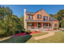 Charming two-story brick home with a welcoming front porch and manicured lawn, perfect for Gathering living at 2436 Green Hollow Ct, Conyers, GA 30012