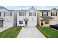 Charming two-story home featuring a light gray exterior, attached garage, and well-maintained front yard at 150 Chandler Trce, Covington, GA 30016