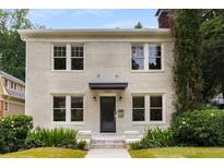 Charming two-story home featuring a brick facade, well-manicured lawn, and inviting front entrance at 851 Courtenay Ne Dr, Atlanta, GA 30306