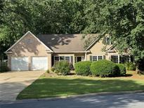 Charming single-Gathering home with a lush lawn, mature trees, and a two-car garage at 780 Karingway Nw Ln, Kennesaw, GA 30152