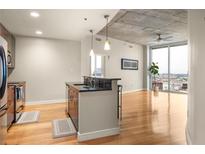 Bright condo living space featuring an open kitchen, hardwood floors, and large windows with city views at 44 Peachtree Ne Pl # 1824, Atlanta, GA 30309