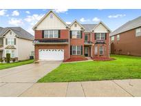 Beautiful two-story brick home with a manicured lawn and attached two car garage at 1212 Ashton Park Dr, Lawrenceville, GA 30045