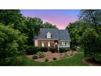 Charming brick home with a inviting front porch and lush, mature landscaping at 2610 Ginger Dr, Buford, GA 30519
