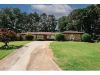 Charming single-story home with stone accents, lush lawn, and a long driveway at 3257 Georgian Woods Cir, Decatur, GA 30034