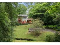 Two-story home with a red deck surrounded by lush greenery and a well-maintained lawn at 998 Northrope Ne Dr, Atlanta, GA 30324