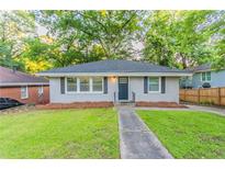 Charming single-story house with green lawn, dark door, and mature trees at 1760 Spring Ave, Atlanta, GA 30344