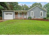 Charming single-story home with a well-manicured lawn and inviting front porch at 295 Pinehurst Dr, Stockbridge, GA 30281
