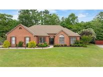 Charming brick home featuring a manicured lawn and mature landscaping enhancing curb appeal at 425 Starfire Ct, Suwanee, GA 30024