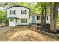 Charming two-story home featuring a bright blue front door, contrasted by dark shutters and fresh landscaping at 4510 Virginia Nw Ave, Kennesaw, GA 30144