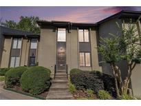 Two-story home with neutral-toned siding, complemented by manicured shrubs and trees and a warm and inviting entrance at 26 Ivy Ne Pkwy, Atlanta, GA 30342