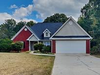 Charming single-Gathering home featuring a two-car garage, beautiful lawn and mature trees at 115 Hugh Dr, Covington, GA 30016