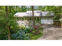 Charming home featuring a welcoming front porch, a two-car garage, and colorful landscaping at 1526 Oakleaf Dr, Auburn, GA 30011