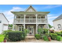 Charming two-story home featuring a welcoming front porch and landscaped front yard at 266 Monarch Village Way, Stockbridge, GA 30281