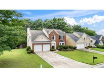 Charming two-story home featuring a well-manicured lawn, brick accents, and a two-car garage at 3614 Clearbrooke Way, Duluth, GA 30097