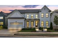 Charming white brick home with a covered porch, well-manicured lawn, and a two-car garage at 401 Pirkle Ave, Buford, GA 30518