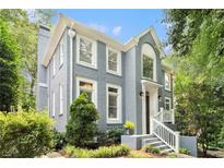 Beautiful gray painted brick home with white trim surrounded by mature trees and manicured landscaping at 29 Greenland Trce, Atlanta, GA 30342