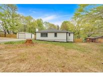 View of the home's backyard with storage and detached garage, landscaping, and fencing at 484 Lorene Sw Dr, Marietta, GA 30060