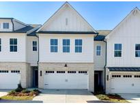Charming new construction townhome with white siding, brick accents, and a two-car garage at 2407 Malster Ln, Lawrenceville, GA 30043