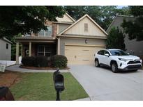 Charming two-story home with a well-manicured lawn, a covered front porch, and a two-car garage at 5230 Centennial Hill Nw Dr, Acworth, GA 30102