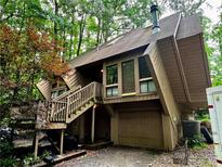 Unique two-story home with a two-car garage and wooden steps in a wooded area at 2965 Pond View Ct, Marietta, GA 30062