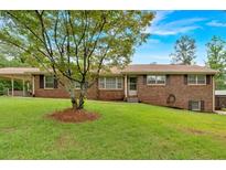 Charming single-story brick home with well-manicured lawn and mature landscaping at 597 Rich Davis Rd, Hiram, GA 30141