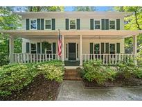 Charming two-story home features a inviting front porch with a swing and an American flag at 6360 Lakeview Ter, Douglasville, GA 30135