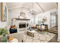 Bright living room with white-painted brick fireplace, modern chandelier, and lots of natural light at 1002 Forrest Blvd, Decatur, GA 30030