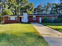 Charming brick home with a well-manicured lawn and classic architectural details at 7054 Chappell Cir, Atlanta, GA 30360