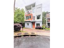 Modern three-story home featuring a unique architectural design with a bright orange door and matching balcony accents at 1463 Macklone Ne St, Atlanta, GA 30307