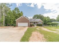 Charming brick home featuring an attached garage, landscaped yard, and inviting front entrance at 1623 Pratt Rd, Covington, GA 30014