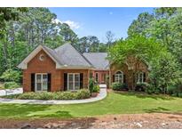 Charming brick home features a well-manicured lawn and mature trees, offering great curb appeal at 25 Highlands Way, Oxford, GA 30054