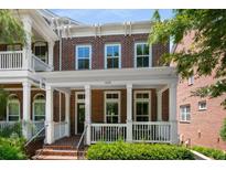 Charming brick townhouse featuring a covered front porch with classic white columns and trim details at 623 Brennan Dr, Decatur, GA 30033