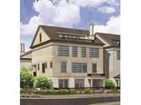Three-story brick townhouse features dark-trimmed windows, a small balcony, and professional landscaping at 205 Mayfair Ct, Alpharetta, GA 30009