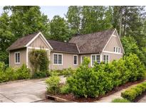 Charming single-story home featuring a lush green yard with well-manicured landscaping and a private driveway at 385 Anders N, Chattahoochee Hills, GA 30268