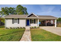 Charming single-story home featuring a well-manicured lawn, a stone walkway and an attached carport at 1450 Walker Se St, Smyrna, GA 30080