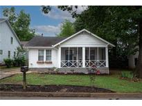 Charming home with a white exterior, inviting screened-in porch, and well-maintained front yard at 3116 Jackson St, Hapeville, GA 30354