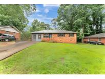 Charming one-story brick home with a spacious front yard and mature trees, offering great curb appeal at 3553 Lakeview Dr, Rex, GA 30273