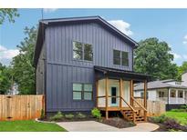 Charming two-story home with vertical siding, a covered porch, and manicured landscaping at 1129 Victory Sw Dr, Atlanta, GA 30310