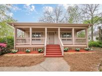 Charming single-story home featuring a welcoming front porch with painted steps and manicured landscaping at 134 N Alexander St, Buford, GA 30518