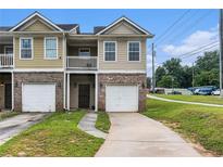 Inviting townhouse with attached garage, balcony, and a well-maintained lawn at 2996 Jonesboro Road Southeast Se Rd # J, Atlanta, GA 30354
