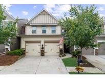 Charming two-story home featuring a two-car garage, neutral siding, and a well-manicured lawn at 3504 Castleberry Village Cir # 36, Cumming, GA 30040