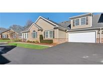 Inviting townhouse with a two-car garage, lush lawn, and lovely landscaping at 2565 Grapevine Cir # 103, Cumming, GA 30041