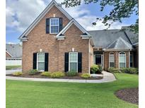 Charming brick home featuring black shutters, lush lawn, and professionally landscaped front yard at 5250 Villa Lake Ct, Suwanee, GA 30024