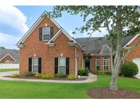 Charming brick home with black shutters, a manicured lawn, and lush landscaping at 5250 Villa Lake Ct, Suwanee, GA 30024