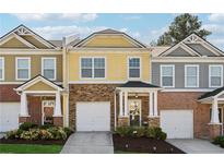 Charming two-story townhome with brick and siding accents and a one-car garage at 771 Arbor Gate Ln, Lawrenceville, GA 30044