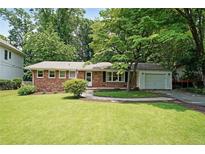 Charming brick home with well-maintained lawn, mature trees, and a one-car garage at 2394 Burch Ne Cir, Brookhaven, GA 30319